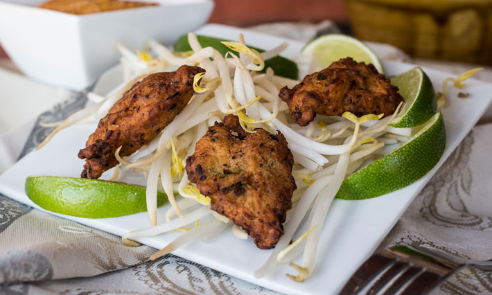 Spicy Thai Sardine Fritters on a bed of bean sprouts and lime wedges